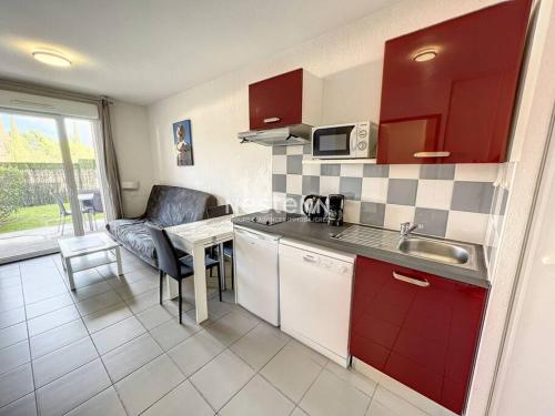 uma pequena cozinha com um lavatório e uma mesa em Appartement 4 couchages avec piscine em Argelès-sur-Mer