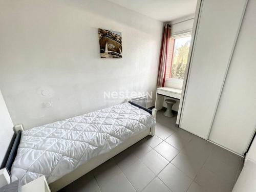 um quarto com uma cama, uma janela e um espelho em Appartement 4 couchages avec piscine em Argelès-sur-Mer