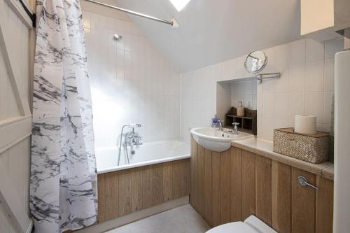 a bathroom with a tub and a sink and a toilet at Mill Village 68, Somer House - P in Somerford Keynes