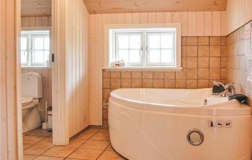 ein Bad mit einer Badewanne und einem WC in der Unterkunft 4 Bedroom Cozy Home In Tranekr in Hou