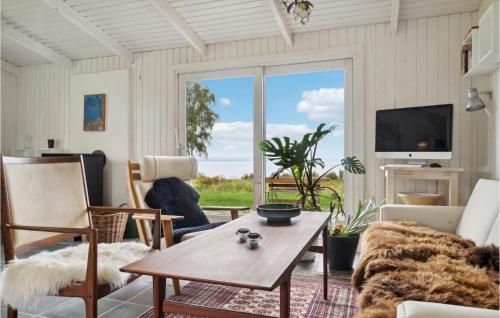 a living room with a table and a large window at 3 Bedroom Gorgeous Home In Knebel in Knebel