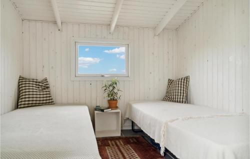 two beds in a white room with a window at 3 Bedroom Gorgeous Home In Knebel in Knebel