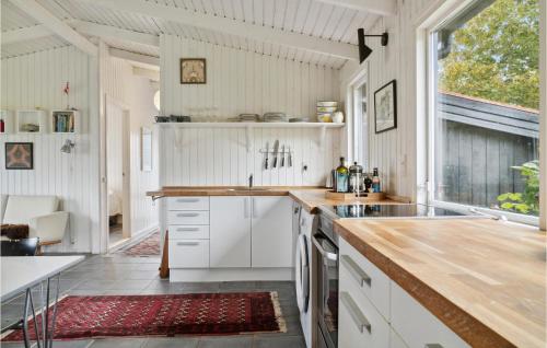 a kitchen with white cabinets and a large window at 3 Bedroom Gorgeous Home In Knebel in Knebel