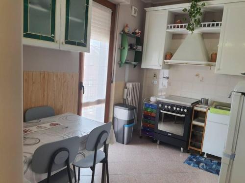 Il comprend une petite cuisine équipée d'une table et d'une cuisinière. dans l'établissement Appartamento Vinovo Centro, à Vinovo