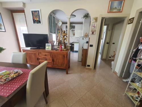 a living room with a table with a television and a dining room at Appartamento Vinovo Centro in Vinovo