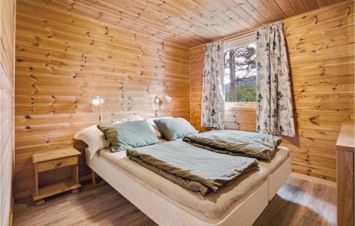 ein Schlafzimmer mit einem Bett in einem Blockhaus in der Unterkunft Stunning Home In Valevg With Kitchen in Valevåg