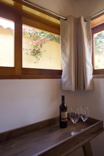 a bottle of wine and two wine glasses on a table at Casafranca in Ollantaytambo