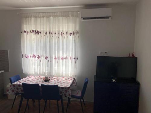 una sala da pranzo con tavolo, sedie e finestra di Studio apartman a Knin (Tenin)