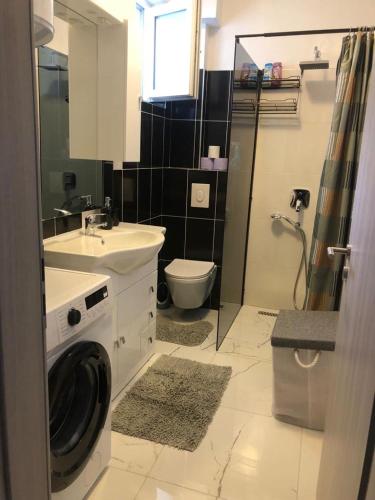 a bathroom with a sink and a washing machine at Studio apartman in Knin