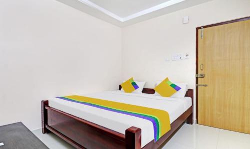 1 dormitorio con 1 cama con manta de arco iris en vardhan @stay inn, en Tirupati