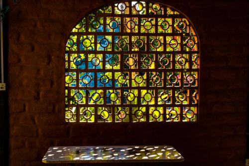 a stained glass window with a bench in front of it at Espaço Shanti - Chalés in Sao Jorge