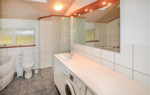 uma casa de banho com um lavatório, uma banheira e um WC. em 3 Bedroom Beautiful Home In Grenaa em Grenå