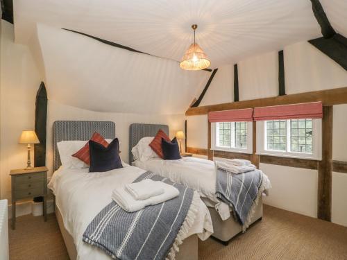 two beds in a room with two windows at Byways in Malvern Link