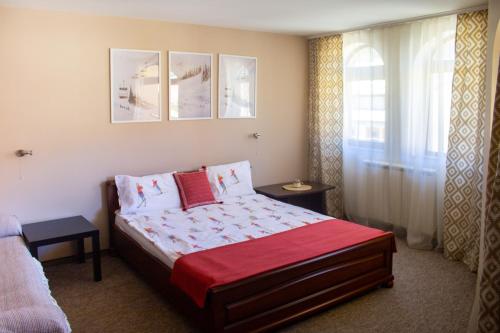 a bedroom with a bed with a red blanket at Meteor Family Hotel in Chepelare