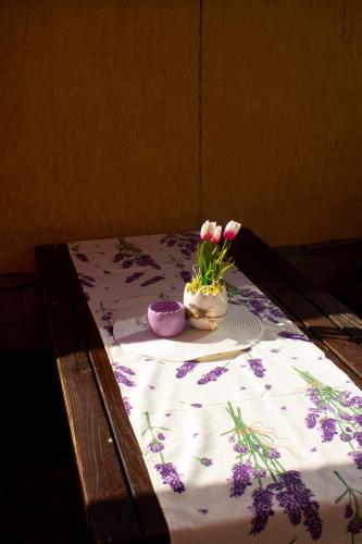 a table with a table cloth with a vase of flowers at Meteor Family Hotel in Chepelare