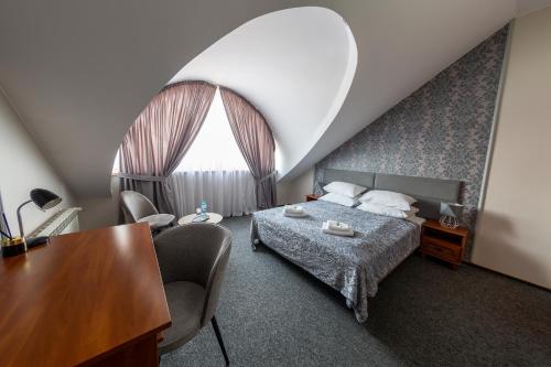 a bedroom with a bed and a table and chairs at Hotel Everest in Węgrów