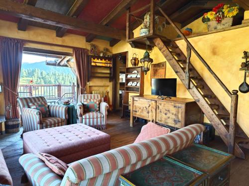 a living room with couches and a staircase in a house at Hostdomus - Imperial Chalet in Sestriere