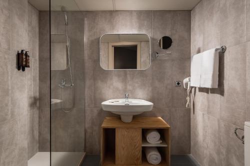 リョレート・デ・マルにあるALEGRIA Fenals Marのバスルーム(洗面台、ガラス張りのシャワー付)