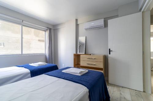 1 Schlafzimmer mit 2 Betten und einem Fenster in der Unterkunft Apto 3min da Praia de Balneário Camboriú ERO301 in Balneário Camboriú