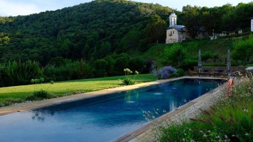 uma piscina numa colina com uma casa ao fundo em Dionisia's Home, Pool, Spa on Monviso UNESCO ALPS em Verzuolo