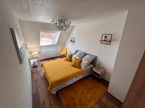 um quarto com uma cama com um cobertor amarelo em LE NOUVEAU VAUBAN em Colmar