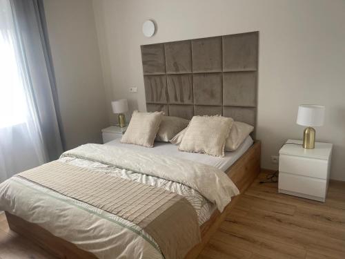 a bedroom with a large bed and two night stands at MW3 Apartament in Rzeszów