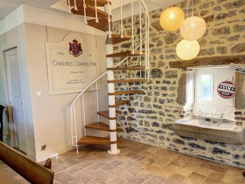 una scala a chiocciola in una camera con parete in pietra di Maison de vacances au cœur de la nature a Sully