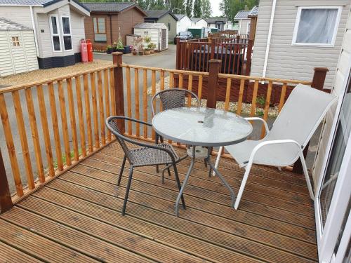 a table and two chairs on a deck at 24 Shark Island in Great Billing