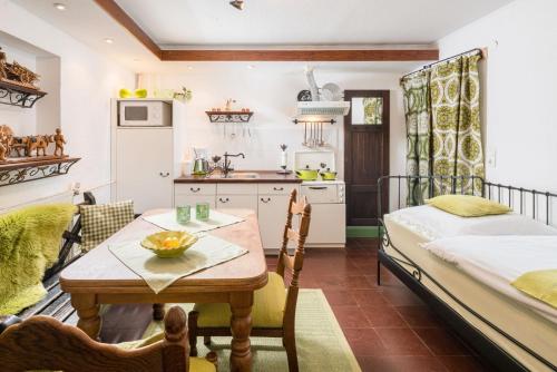 a kitchen and dining room with a table and a bed at Regina's Gästehaus in Weisenbach