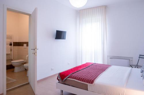 a white bedroom with a bed and a toilet at Ca' Popolo Venice in Mestre