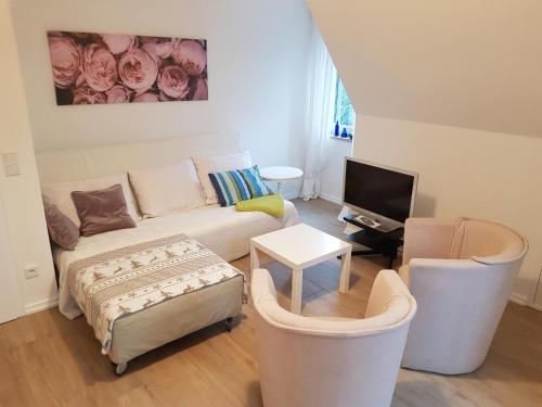 a living room with a couch and two chairs at Ferienhaus Bendestorf vor den Toren Hamburgs in Bendestorf