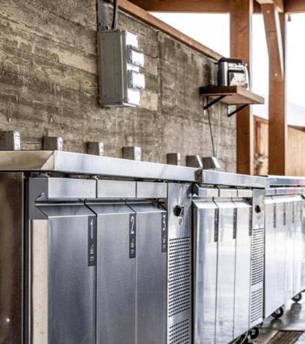 a row of refrigerators are lined up against a wall at Layla Glamping in Nir Dawid
