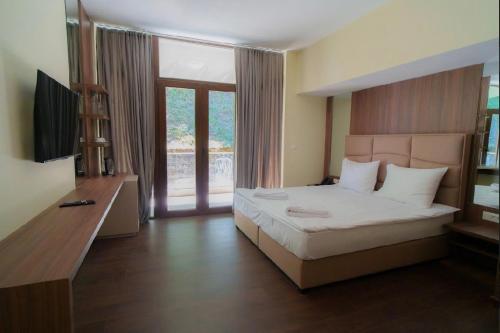 a bedroom with a large bed and a television at Panorama Hotel & Spa in Kruševo