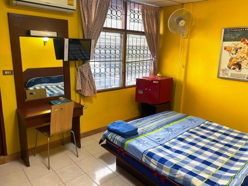 ein Schlafzimmer mit Bett, Schreibtisch und Fenster in der Unterkunft Riviera Beach in Pattaya