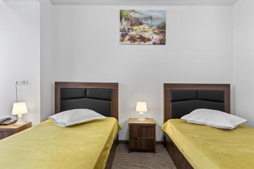 dwa łóżka siedzące obok siebie w pokoju w obiekcie Lina Hotel w Bukareszcie