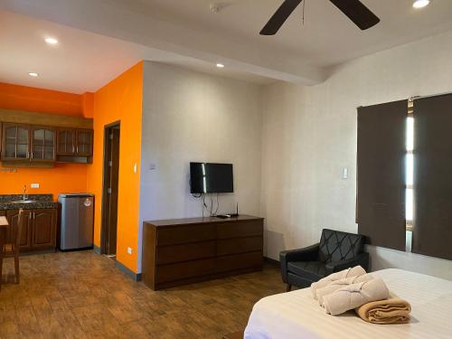 una camera con letto, TV e sedia di El Puerto Marina Beach Resort & Vacation Club a Lingayen