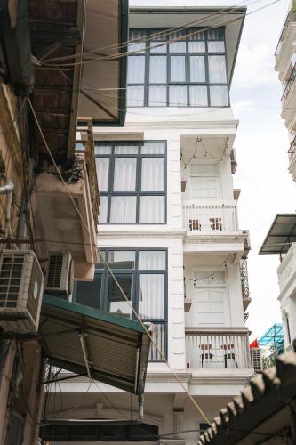 - un bâtiment blanc avec des fenêtres et un balcon dans l'établissement Dalili Homestay - A homestay with 3 fully equipped studio in Hanoi old quarter, à Hanoï