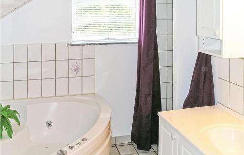 a white bathroom with a tub and a window at Amazing Home In rsted With 3 Bedrooms, Sauna And Wifi in Kare