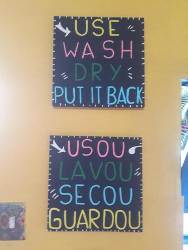 two signs hanging on a wall with the words use washi dry put it back at Perto Do Aeroporto De Salvador - Dona Pitanga Hostel in Lauro de Freitas