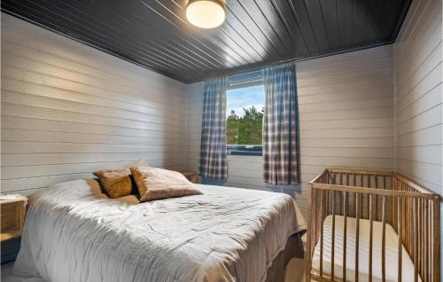 Valevåg的住宿－Beach Front Home In Valevg With Sauna，一间卧室设有一张床、一个窗口和一张婴儿床