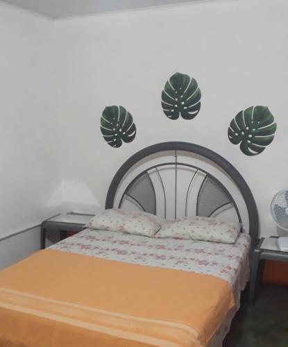 a bedroom with a bed with four leaves on the wall at Perto Do Aeroporto De Salvador - Dona Pitanga Hostel in Lauro de Freitas