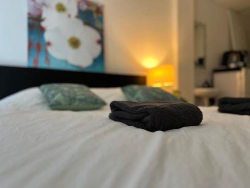 two towels sitting on top of a white bed at Cozy Private Room 1 on a Busy Persian Restaurant in Eindhoven