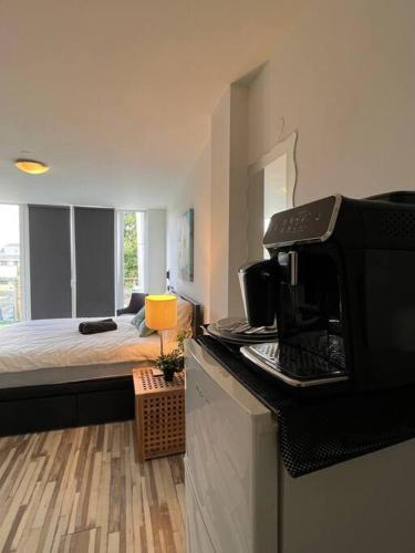 a kitchen with a microwave and a bedroom with a bed at Cozy Private Room 1 on a Busy Persian Restaurant in Eindhoven