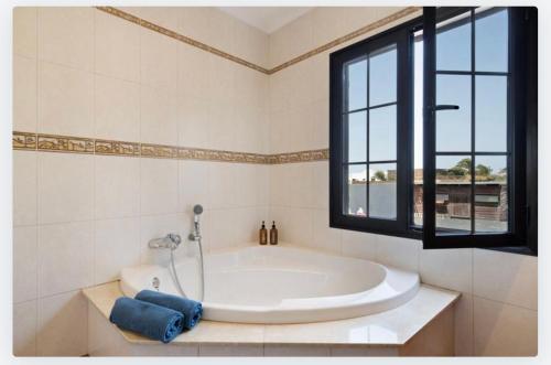 baño con bañera grande y ventana en Villa Petronila Tías, LANZAROTE en Conil