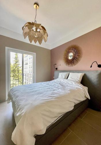 une chambre avec un grand lit avec un miroir au mur dans l'établissement Air-conditioned apartment with garage near the sea, à Nice