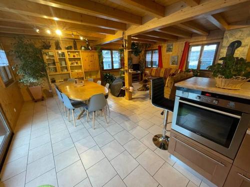 eine Küche und ein Esszimmer mit einem Tisch und Stühlen in der Unterkunft La Grange à Coco avec jacuzzi in Bourg-Saint-Pierre