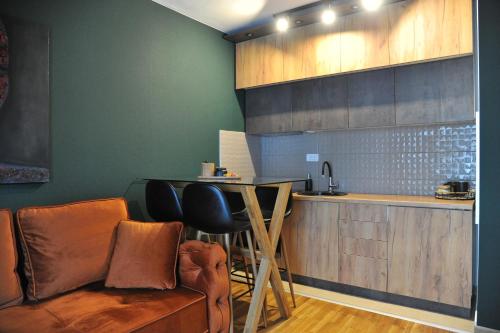 a kitchen with a bar with a couch and a table at Apartman Ljubica in Vrnjačka Banja