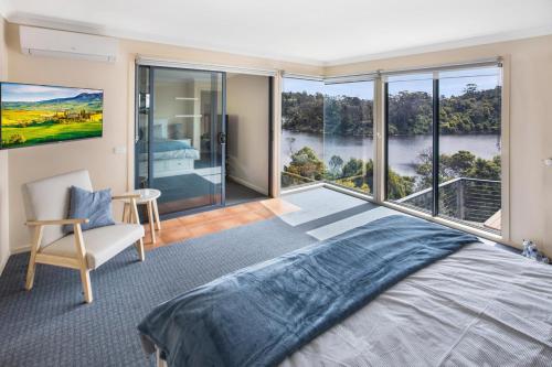 a bedroom with a large bed and a large window at Arukah House in Lakes Entrance