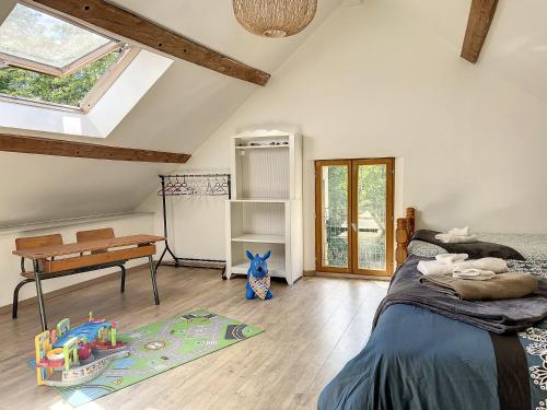 1 dormitorio con cama, escritorio y mesa en Maison de vacances au cœur de la nature en Sully