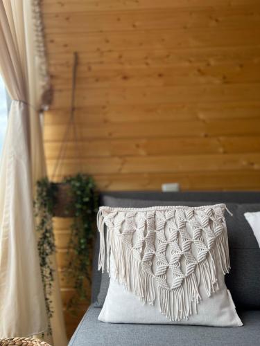 a pillow on a couch with a wooden wall at Woodhide - Cottages near Batumi, Georgia in Zeda Ch'khutunet'i